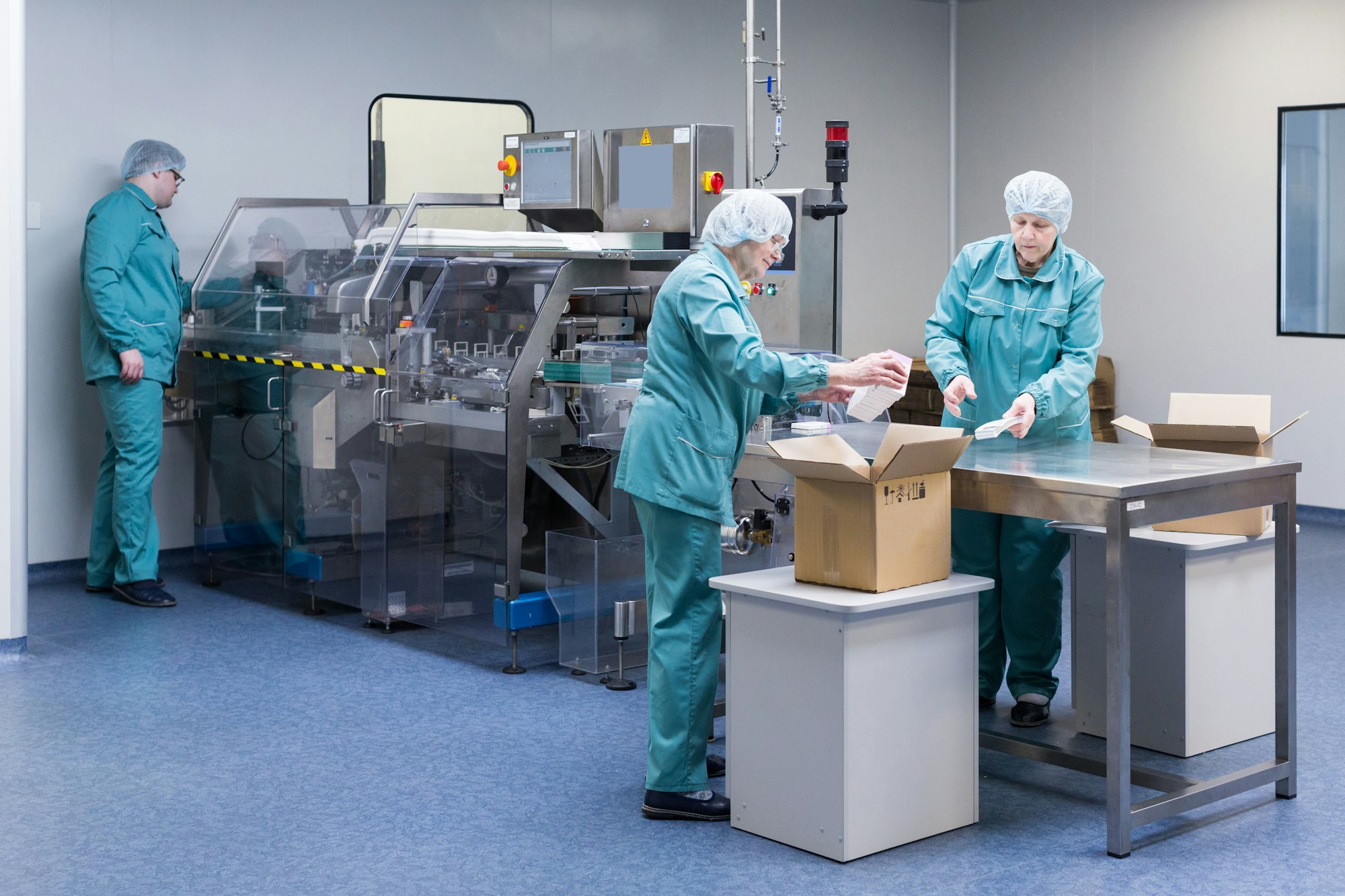 Pharmaceutical factory workers in sterile environment.