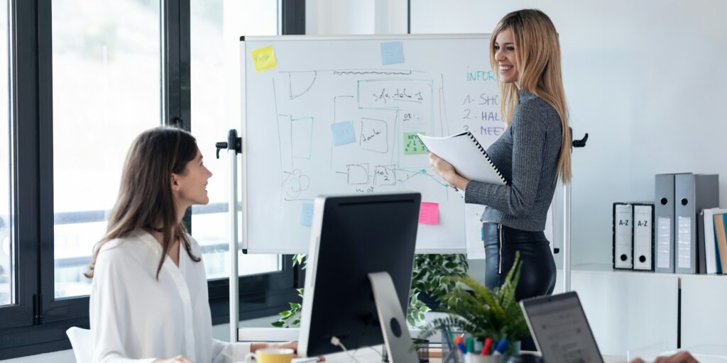 businessteam talking while explain a project to their colleagues in white blackboard