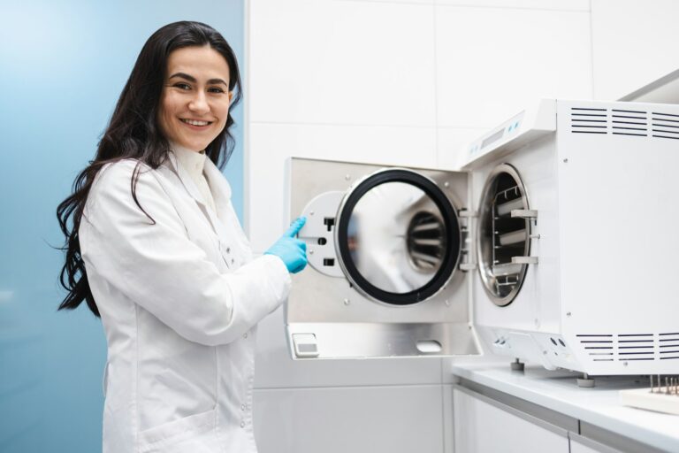 Medical worker in the instrument sterilization room. Doctor assistant working with autoclave