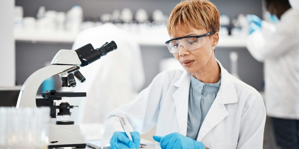 Scientist, woman and writing lab report with results, focus or analysis for pharma development. Sci