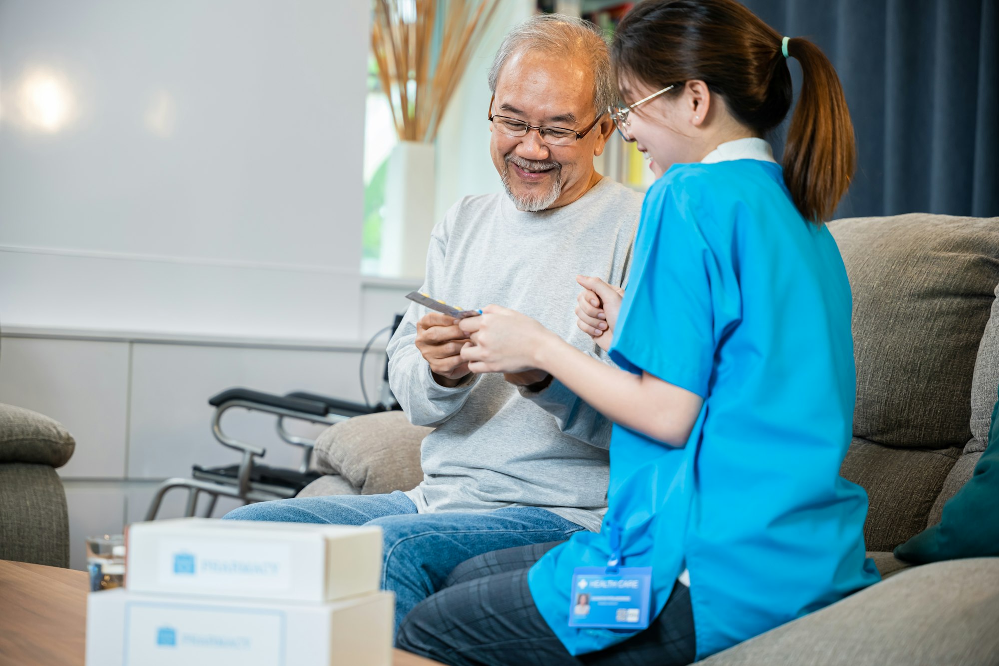 Woman nurse caregiver show prescription drug to senior man at nursing home