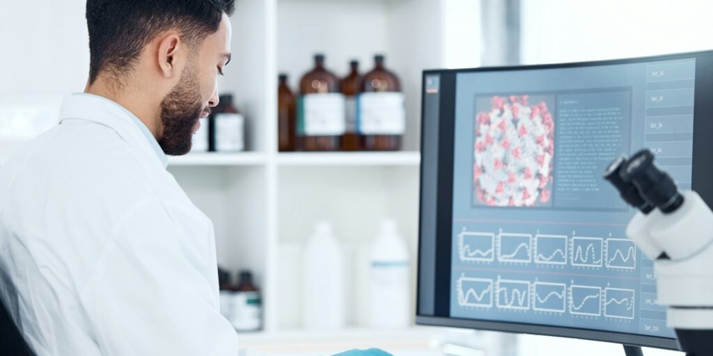 One mixed race scientist from the back analysing medical test samples and data from microbiology an