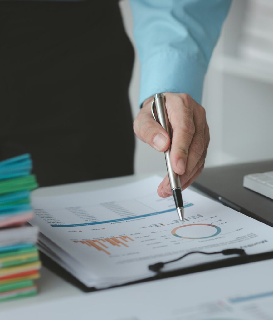 A business finance man is reviewing a company's financial documents prepared by the Finance Departme