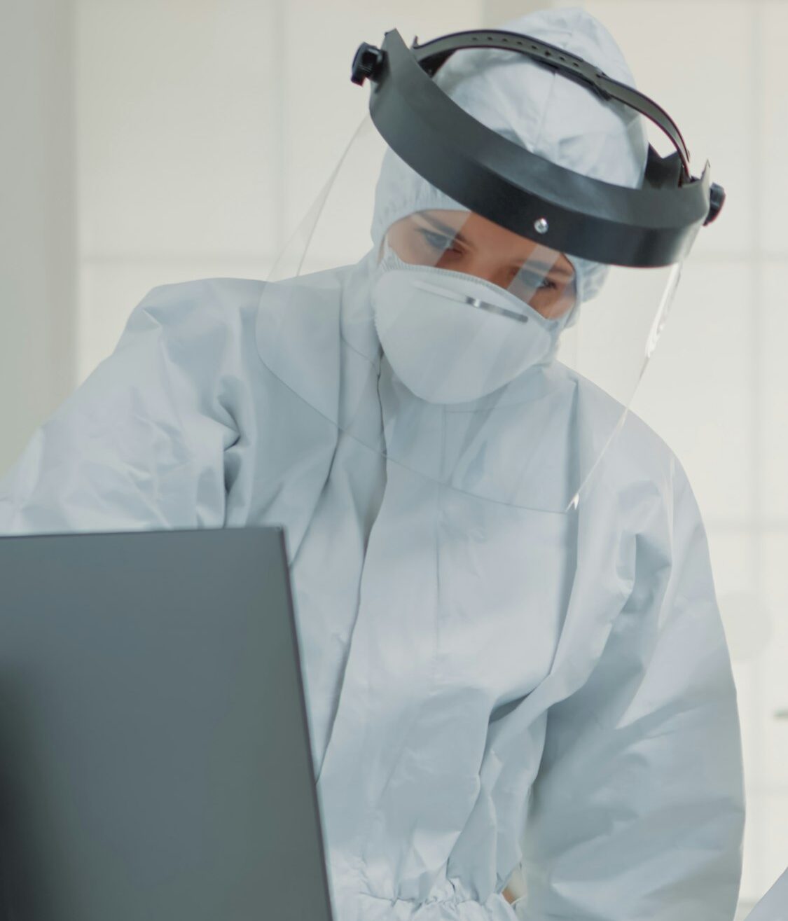 Dentistry team of specialists with ppe suits using computer