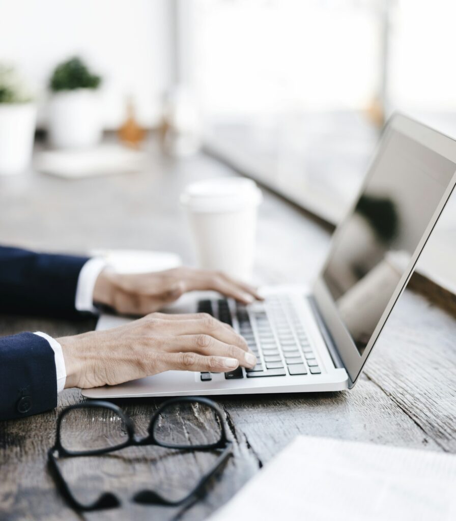 Hands of businesswoman using laptop in a cafe