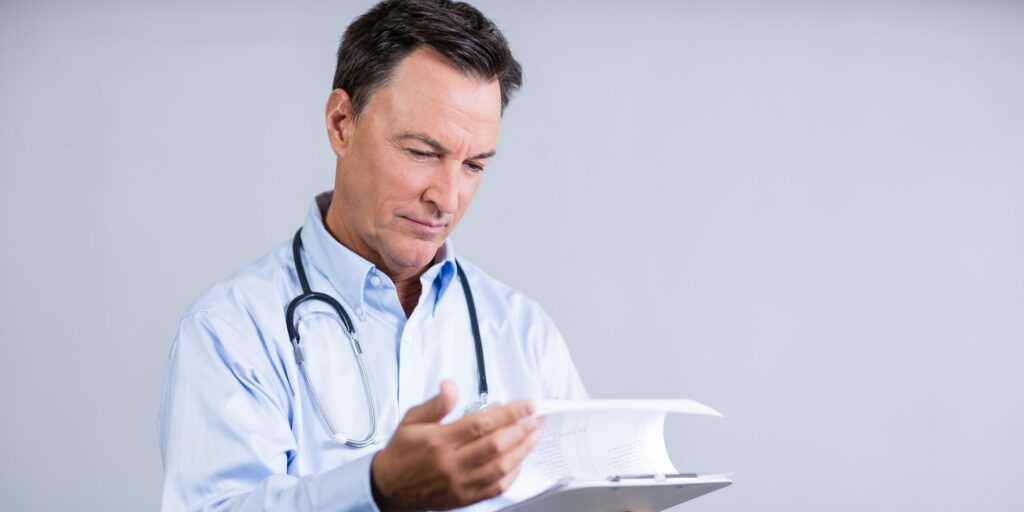 Male doctor reading reports