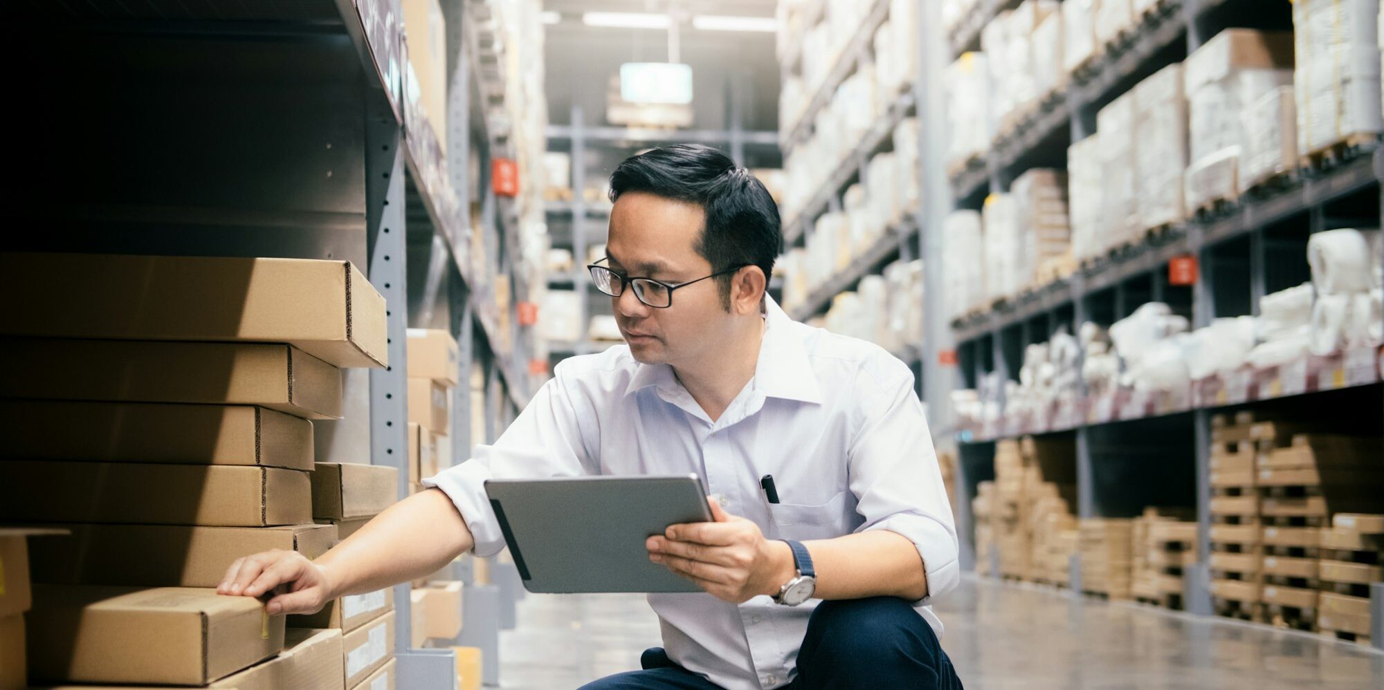 Man warehouse worker checking goods at warehouse.