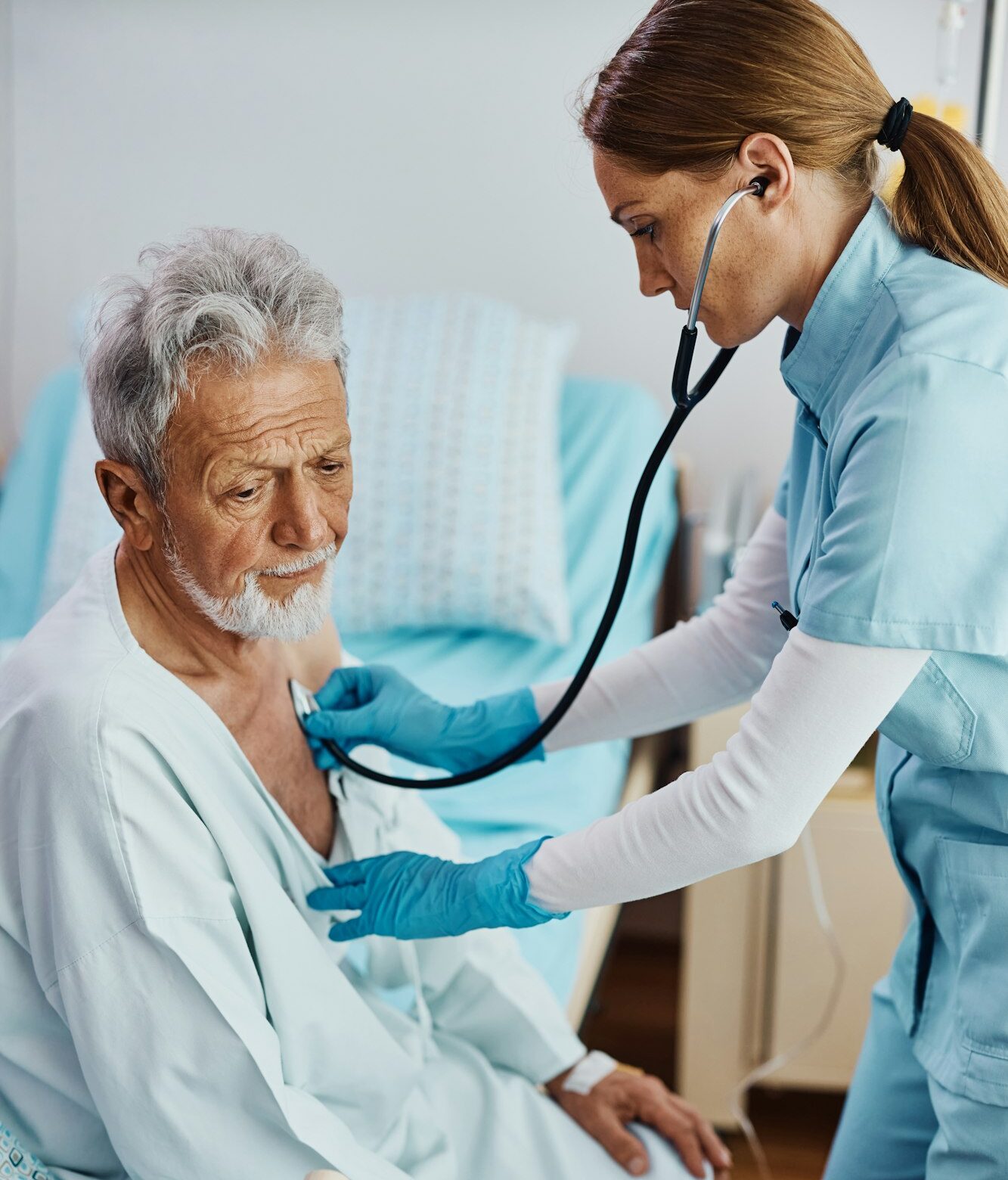 Nurse listening heartbeat of recovering senior patient in the hospital ward. Nurse listening heartbeat of recovering senior patient in the hospital ward.
