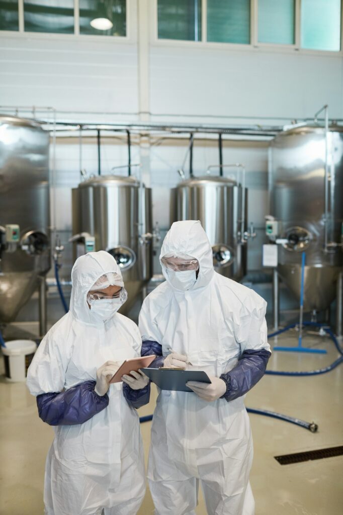 Two Chemical Plant Workers Supervising Production