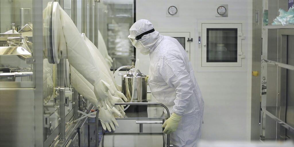 Worker At Pharmaceutical Factory. Lab technician working inside a pharmaceutical factory