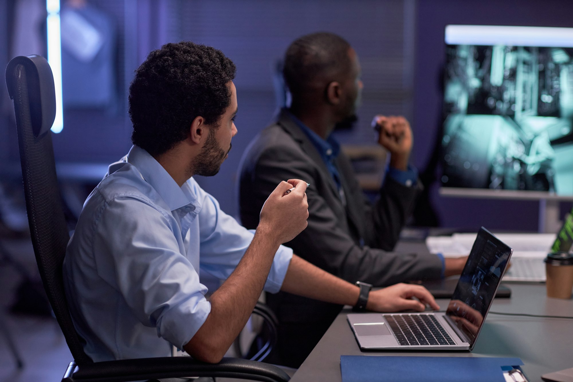 Two men looking at screen during meeting in IT security office