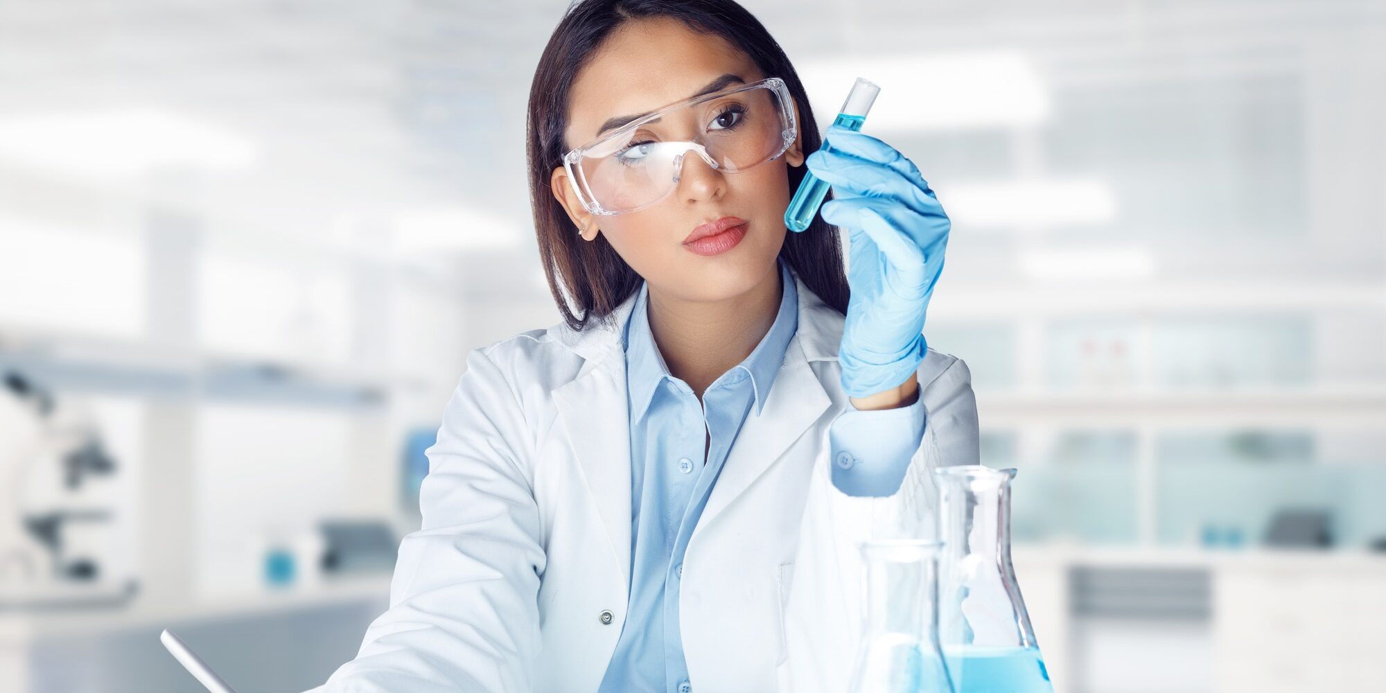 Female lab technician analyzing liquid sample