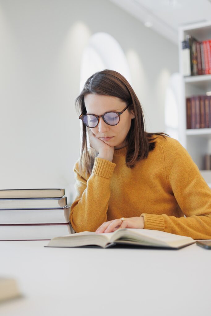 confident woman works in library, in coworking at laptop or office. female student is studying