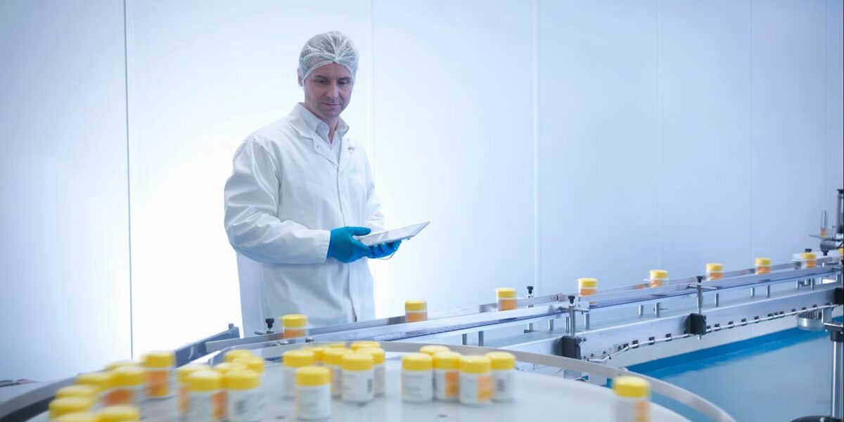 Regulated pharmaceutical manufacturing facility during a quality inspection, illustrating pharmaceutical regulatory requirements, GMP compliance guidelines, operational control in GMP facilities, documentation control, and facility audit preparation under global GMP standards.